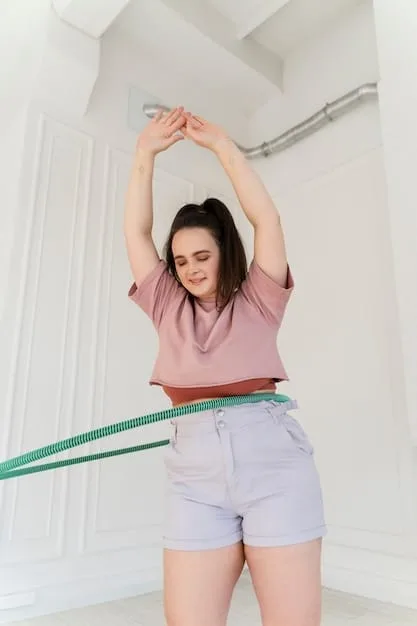 A person using a flexible tape measure to accurately measure their waist, with part of their torso visible. The background is a plain, neutral wall, emphasizing the act of measurement.