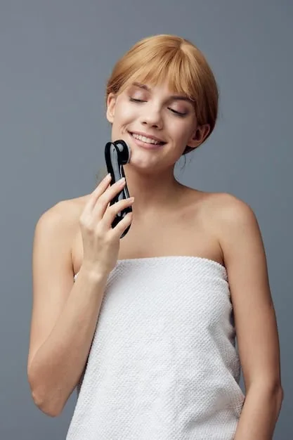 A woman holding a sleek, modern microcurrent facial device, gently gliding it along her jawline, with her skin looking radiant and slightly lifted, set against a minimalist, bright bathroom interior.