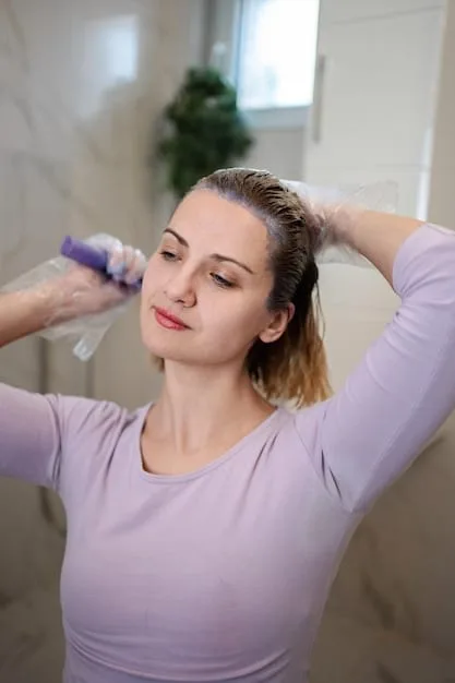 A person gently squeezing excess water from their hair after washing, illustrating the importance of proper drying techniques.