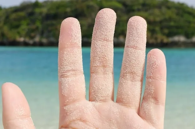 A close-up of a hand applying a white mineral sunscreen, showing the texture and the slight white cast, possibly on a beach background to emphasize reef-safe.
