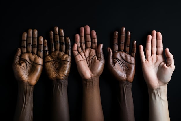 A close-up shot of a diverse group of hands raised in unison, symbolizing a united community voice and collective action. The focus is on the hands, with a blurred background of supportive community members.
