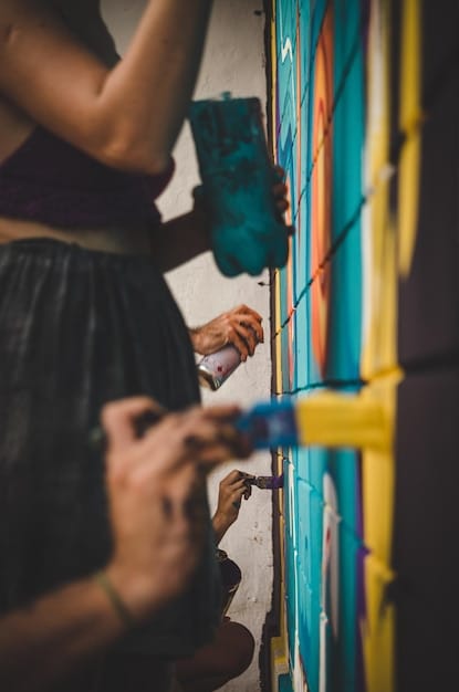 A vibrant mural being painted on a community building, with local artists and residents working together. The image represents community engagement and the power of collaborative art.
