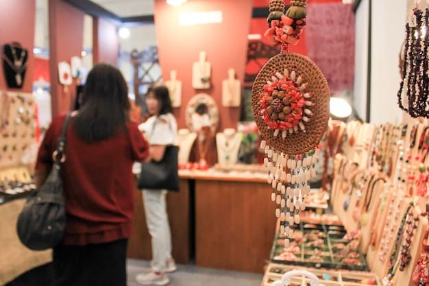 A close-up of a well-organized and visually appealing craft fair booth, showcasing handmade jewelry neatly displayed on tiered stands with good lighting. The vendor is interacting with a customer.