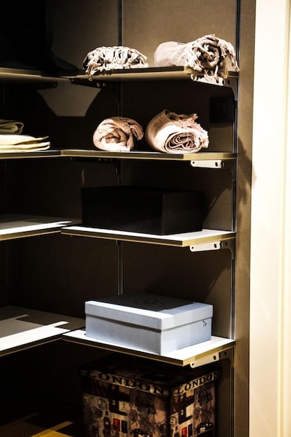 A neatly organized closet with transparent SHEIN storage bins holding folded clothes, and hanging organizers for accessories, showcasing efficient space utilization.