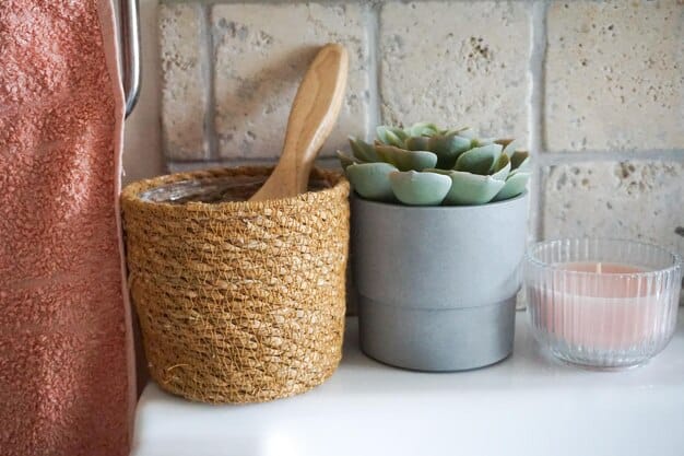 A close-up of a neatly organized bathroom shelf with a mix of SHEIN decor: small faux plants in geometric pots, a stylish soap dispenser, and a stack of folded white towels complemented by a neutral-toned bath mat.