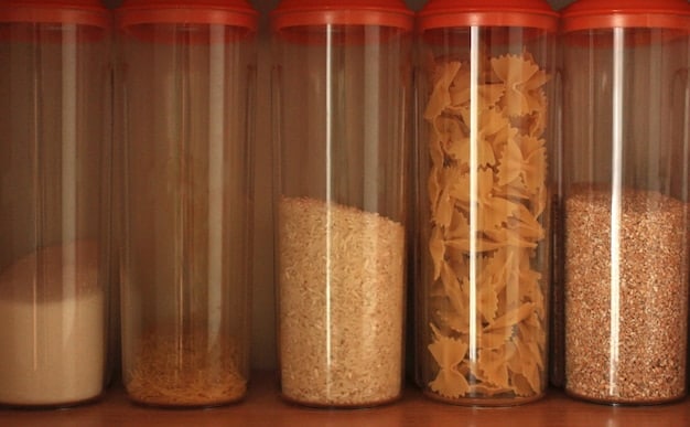 A close-up of a SHEIN clear, stackable food container set in a well-organized pantry drawer, filled with dried goods.