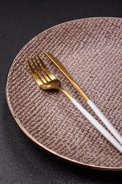 A close-up shot of an elegant SHEIN ceramic plate with a gold rim, paired with simple, modern cutlery, on a textured linen placemat, suggesting a sophisticated US dinner party setting.