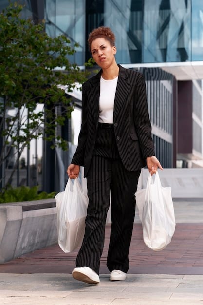 A professional woman in a business-casual blazer and tailored trousers walking purposefully, carrying a structured black SHEIN tote bag with gold hardware, looking confident and business-ready.
