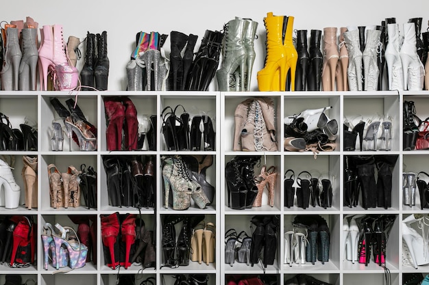 A well-organized shoe closet with neatly arranged SHEIN shoes on shelves and racks. Some shoes have shoe trees inserted, and there are clear storage boxes visible, showcasing effective storage solutions.