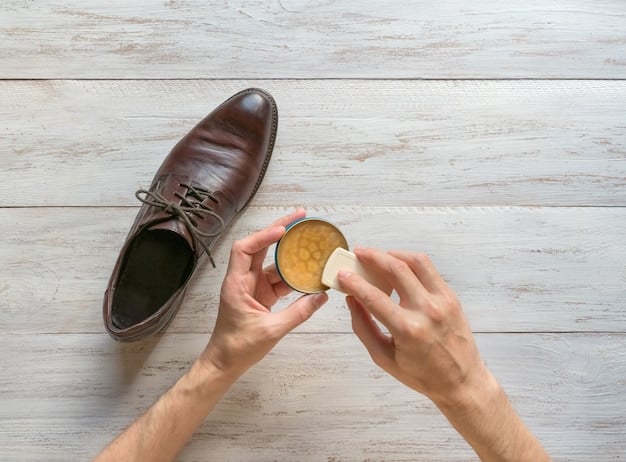 A close-up shot of a person gently cleaning a synthetic leather shoe with a soft, damp cloth, illustrating proper shoe care.