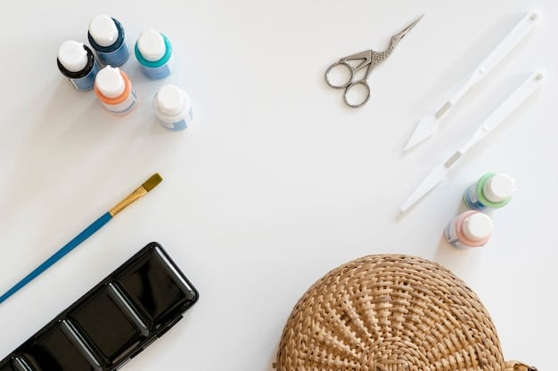 A flat lay of various crafting tools and materials including fabric paints, brushes, E6000 glue, rhinestones, and stencils, neatly organized on a wooden table, suggesting a DIY customization project in progress.