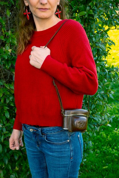 A close-up of a stylish SHEIN faux leather shoulder bag in a rich olive green, showcasing its detailed stitching and high-quality finish, with a blurred natural background.