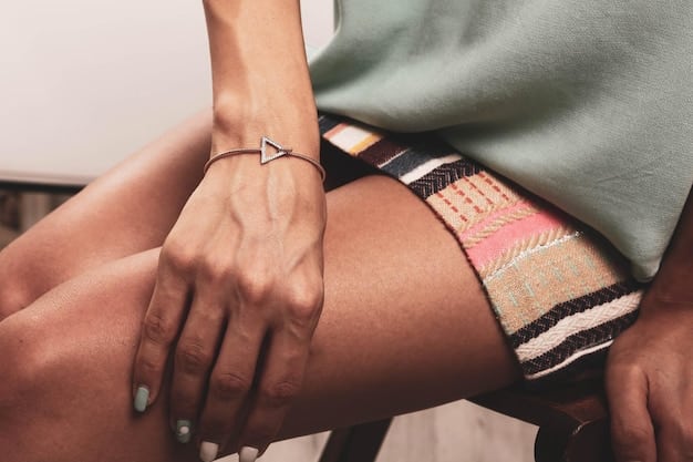 A detailed close-up of a stylish athleisure outfit featuring layered gold necklaces, a sleek smart watch, and stackable rings on a model's hand, enhancing a simple but chic black athleisure top.