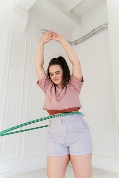 A person using a flexible tape measure to accurately measure their waist, with part of their torso visible. The background is a plain, neutral wall, emphasizing the act of measurement.