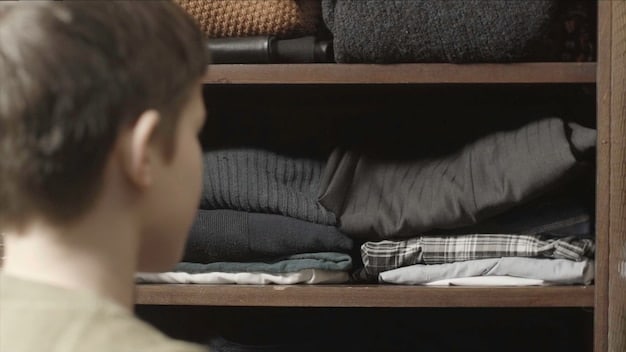 A person thoughtfully organizing their clothes by folding them neatly into drawers, with a focus on simple, dark-colored garments. The setting is clean and minimalist, suggesting mindful organization.