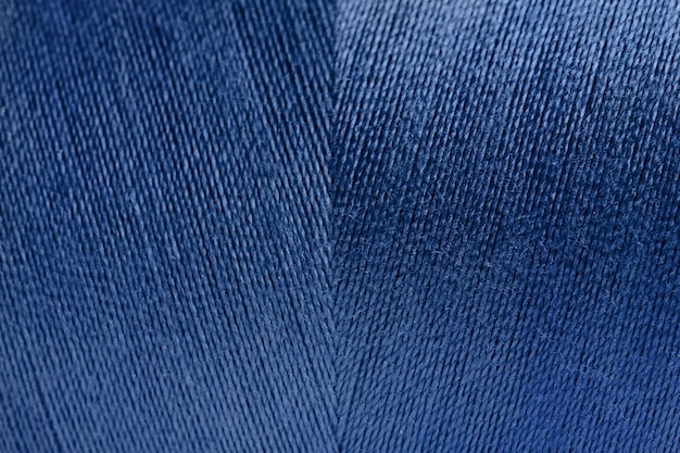 Detailed close-up of a dark blue denim fabric, clearly showing the diagonal twill weave pattern and the texture of the threads.