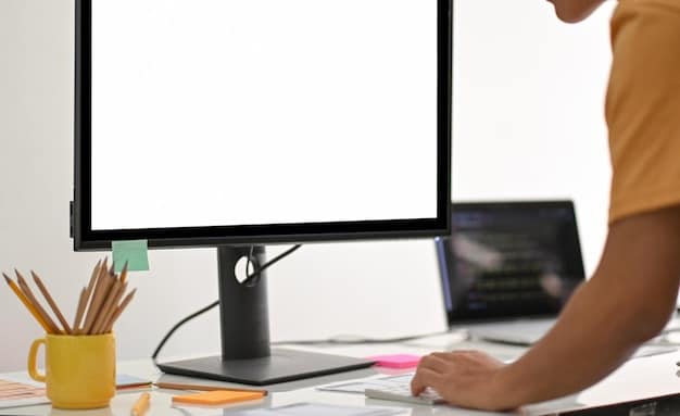 A close-up of a monitor arm securely clamped to a desk, holding a computer monitor at eye level. The screen shows a productivity application, and the background is slightly blurred to emphasize the monitor setup.